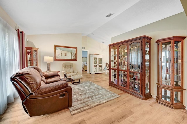 living area featuring vaulted ceiling and light wood-style flooring