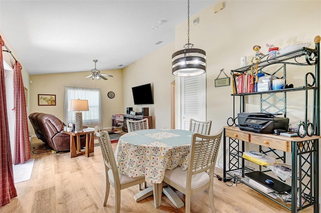 dining room featuring wood finished floors, vaulted ceiling, and a ceiling fan