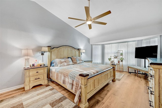 bedroom with light wood-type flooring, high vaulted ceiling, a ceiling fan, and baseboards