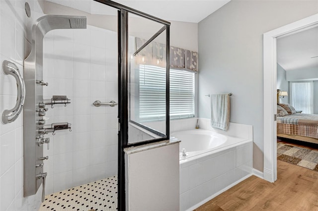 bathroom featuring ensuite bathroom, a stall shower, a garden tub, and wood finished floors