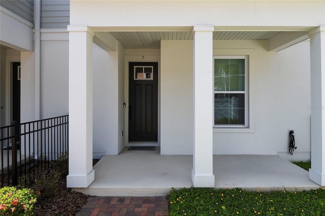 117 E Concord St Unit 7, Orlando, FL 32801 - view of exterior entry with covered porch, stucco siding, and fence