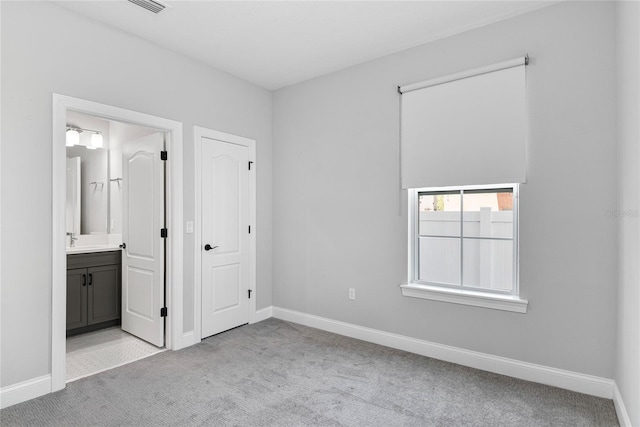 117 E Concord St Unit 7, Orlando, FL 32801 - unfurnished bedroom featuring carpet floors, baseboards, and connected bathroom
