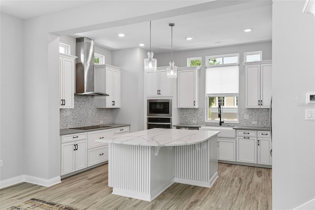 117 E Concord St Unit 7, Orlando, FL 32801 - kitchen with oven, wall chimney range hood, a sink, light wood-type flooring, and recessed lighting