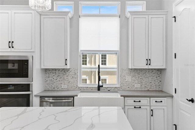 117 E Concord St Unit 7, Orlando, FL 32801 - kitchen with oven, stainless steel dishwasher, a sink, built in microwave, and white cabinetry