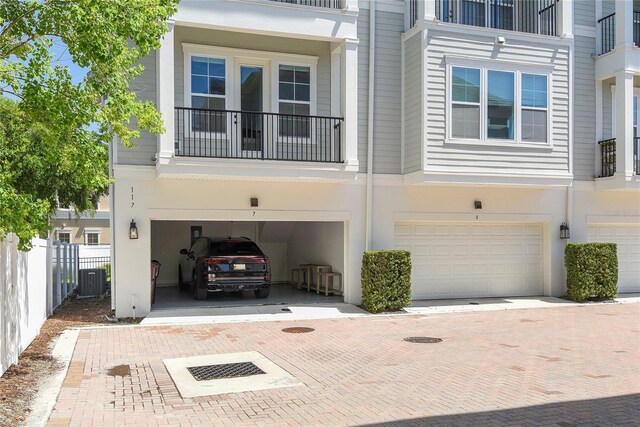 117 E Concord St Unit 7, Orlando, FL 32801 - view of front of property featuring an attached garage, fence, driveway, central air condition unit, and stucco siding