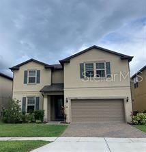 traditional home featuring a garage, driveway, and stucco siding