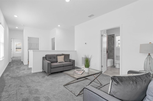 living room with plenty of natural light, recessed lighting, baseboards, and light colored carpet