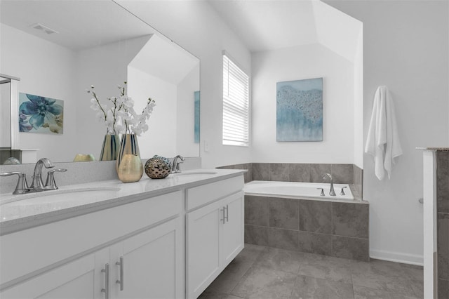 full bathroom featuring a garden tub, double vanity, and tile patterned floors