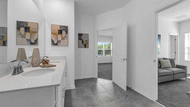 bathroom with baseboards, tile patterned floors, double vanity, and ensuite bath