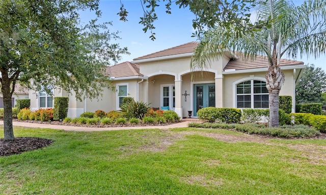 31754 Red Tail Blvd, Sorrento, FL 32776 - view of front of house with a tiled roof, a front yard, french doors, and stucco siding
