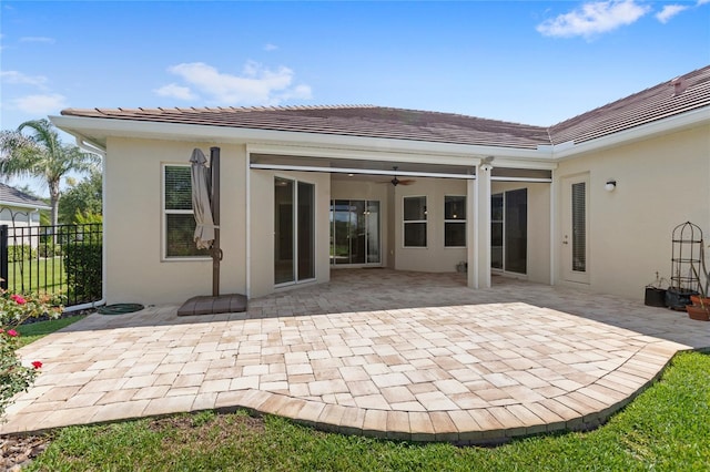 31754 Red Tail Blvd, Sorrento, FL 32776 - back of property featuring stucco siding, fence, a patio area, and a tiled roof