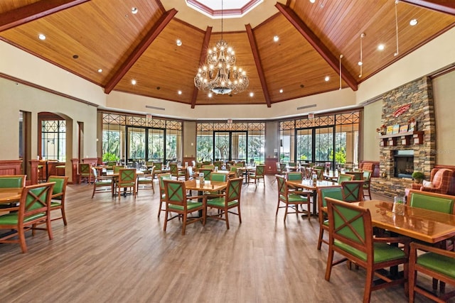 31754 Red Tail Blvd, Sorrento, FL 32776 - dining area featuring wooden ceiling, a stone fireplace, high vaulted ceiling, wood finished floors, and arched walkways
