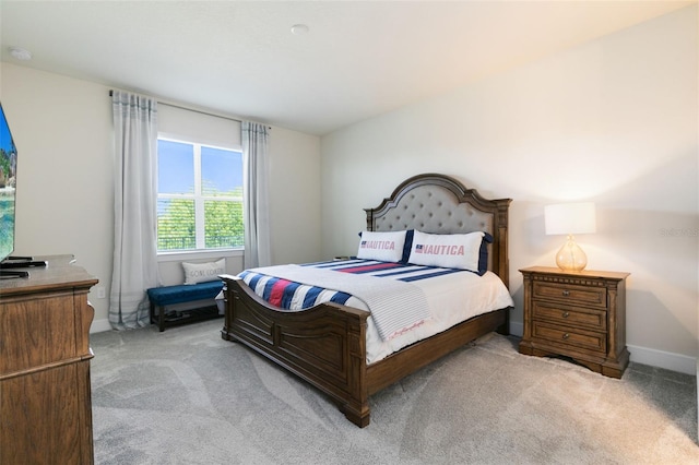 bedroom featuring light colored carpet and baseboards