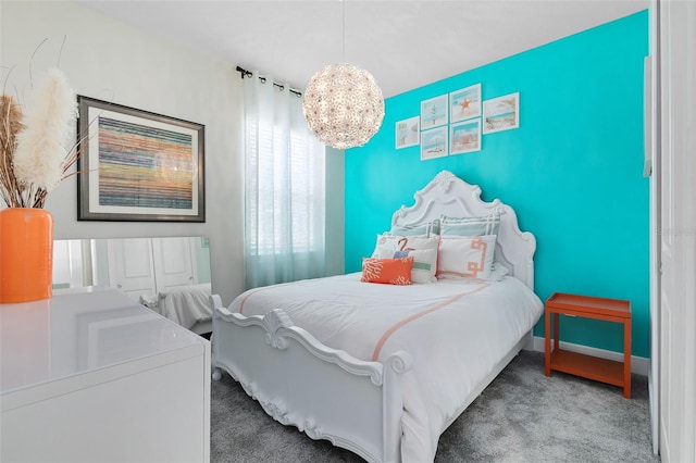 bedroom featuring carpet floors, a chandelier, and baseboards