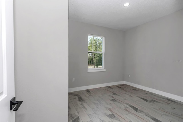 8202 SW 123rd Ter, Dunnellon, FL 34432 - empty room featuring a textured ceiling, baseboards, light wood finished floors, and recessed lighting