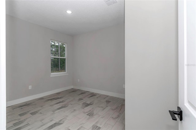 8202 SW 123rd Ter, Dunnellon, FL 34432 - spare room featuring light wood-type flooring, baseboards, a textured ceiling, and recessed lighting