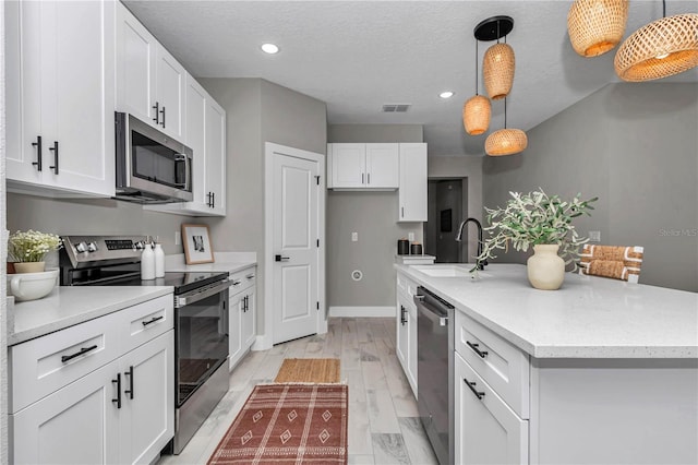 8202 SW 123rd Ter, Dunnellon, FL 34432 - kitchen featuring stainless steel appliances, a sink, white cabinets, a center island with sink, and recessed lighting