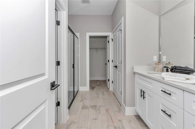 8202 SW 123rd Ter, Dunnellon, FL 34432 - bathroom featuring vanity, a stall shower, a spacious closet, and baseboards