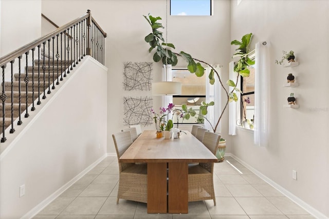 1501 Prairie Oaks Dr, Saint Cloud, FL 34771 - tiled dining area featuring plenty of natural light, stairway, baseboards, and a towering ceiling