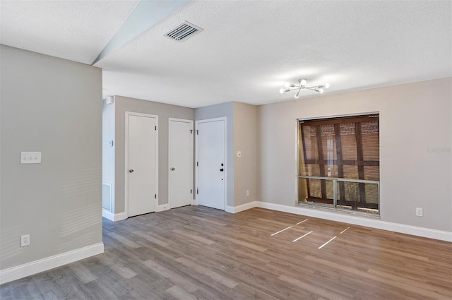 5039 Jamaica Cir Unit 10, Orlando, FL 32808 - empty room with baseboards, wood finished floors, and a textured ceiling
