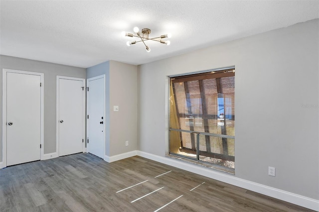5039 Jamaica Cir Unit 10, Orlando, FL 32808 - foyer entrance with wood finished floors, a chandelier, baseboards, and a textured ceiling