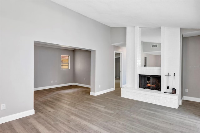 5039 Jamaica Cir Unit 10, Orlando, FL 32808 - unfurnished living room with baseboards, wood finished floors, a fireplace, and high vaulted ceiling
