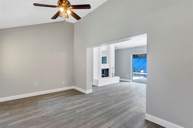 5039 Jamaica Cir Unit 10, Orlando, FL 32808 - unfurnished living room with a ceiling fan, baseboards, wood finished floors, high vaulted ceiling, and a fireplace with raised hearth