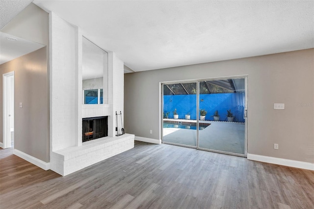 5039 Jamaica Cir Unit 10, Orlando, FL 32808 - unfurnished living room featuring wood finished floors, baseboards, and a brick fireplace