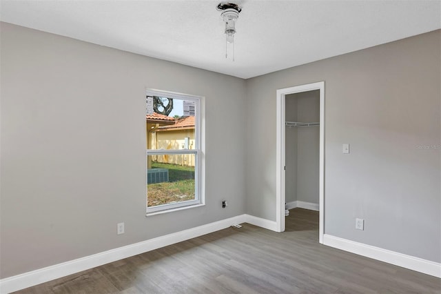 5039 Jamaica Cir Unit 10, Orlando, FL 32808 - unfurnished bedroom featuring wood finished floors, baseboards, a spacious closet, and a closet