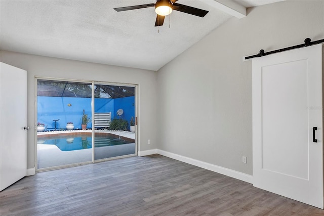 5039 Jamaica Cir Unit 10, Orlando, FL 32808 - spare room featuring a barn door, ceiling fan, wood finished floors, baseboards, and a textured ceiling