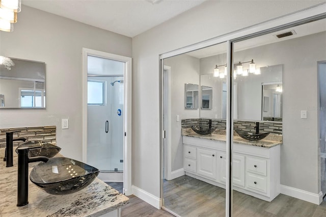 5039 Jamaica Cir Unit 10, Orlando, FL 32808 - full bath with a shower stall, wood finished floors, backsplash, vanity, and baseboards