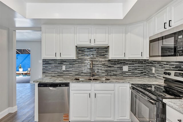 5039 Jamaica Cir Unit 10, Orlando, FL 32808 - kitchen featuring stainless steel appliances, a sink, tasteful backsplash, and white cabinetry
