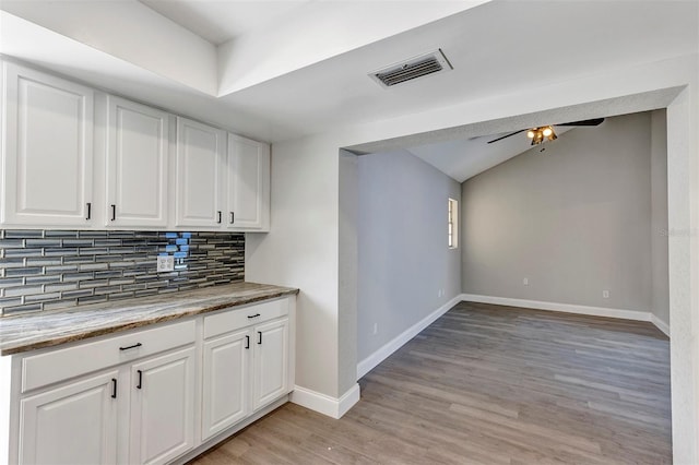 5039 Jamaica Cir Unit 10, Orlando, FL 32808 - bar with decorative backsplash, light wood finished floors, baseboards, a ceiling fan, and lofted ceiling