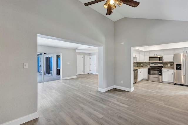 5039 Jamaica Cir Unit 10, Orlando, FL 32808 - unfurnished living room with a ceiling fan, light wood-type flooring, baseboards, and high vaulted ceiling