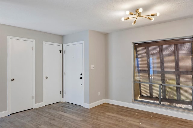 5039 Jamaica Cir Unit 10, Orlando, FL 32808 - entryway with a chandelier, wood finished floors, baseboards, and a textured ceiling
