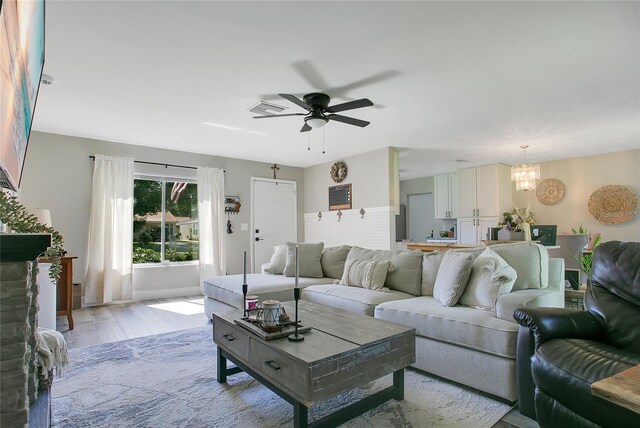 10148 Eventide Ct, Orlando, FL 32821 - living area featuring a chandelier, ceiling fan, and light wood-style floors
