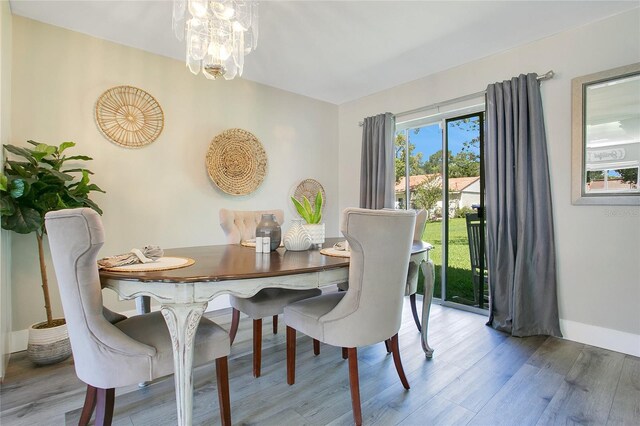 10148 Eventide Ct, Orlando, FL 32821 - dining space featuring wood finished floors, a chandelier, and baseboards