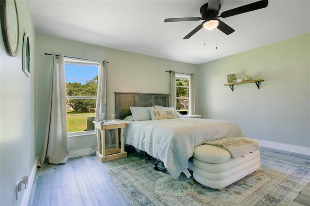 10148 Eventide Ct, Orlando, FL 32821 - bedroom with light wood-type flooring, baseboards, and a ceiling fan