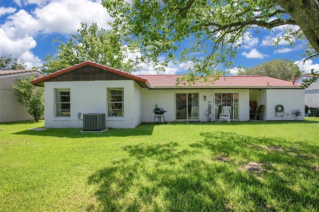 10148 Eventide Ct, Orlando, FL 32821 - back of house with central AC, a tile roof, and a yard