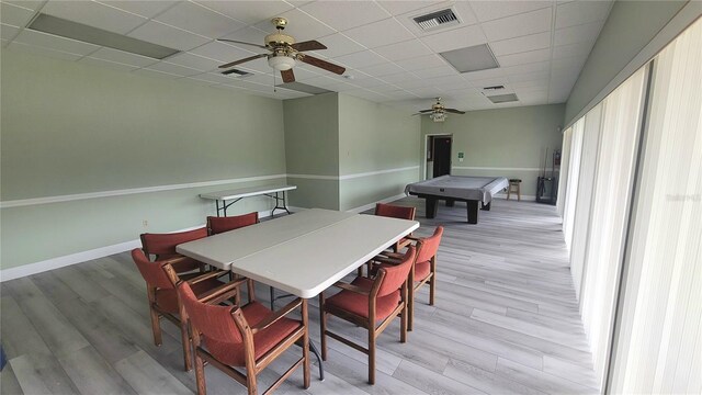 10148 Eventide Ct, Orlando, FL 32821 - dining space with a ceiling fan, light wood-style floors, a paneled ceiling, and baseboards