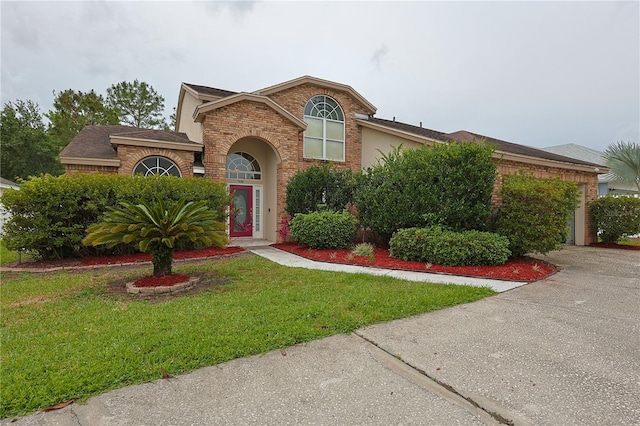 508 Key Ct, Orlando, FL 32828 - traditional-style home with an attached garage, brick siding, a front yard, and concrete driveway