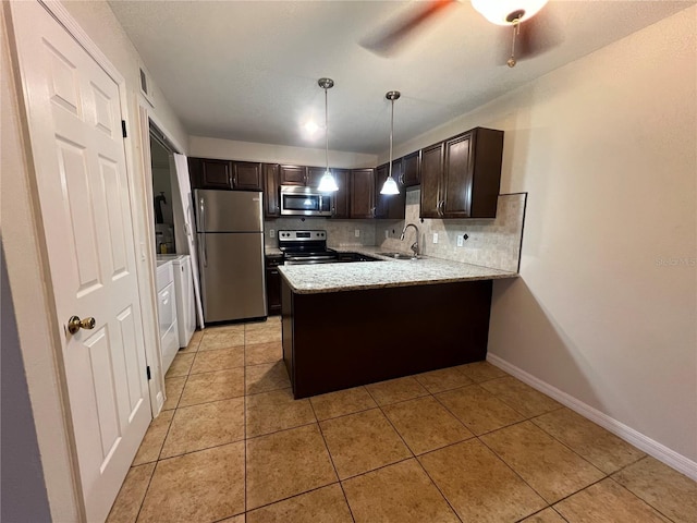 51 Windtree Ln Unit 101, Winter Garden, FL 34787 - kitchen with stainless steel appliances, a peninsula, dark brown cabinets, a sink, and backsplash