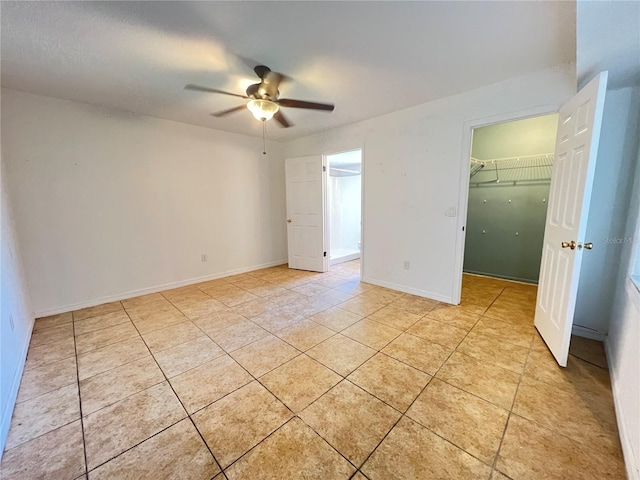 51 Windtree Ln Unit 101, Winter Garden, FL 34787 - unfurnished bedroom featuring a walk in closet, light tile patterned floors, ceiling fan, a closet, and baseboards