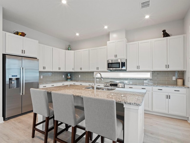 6875 Bridgman St, Orlando, FL 32827 - kitchen featuring appliances with stainless steel finishes, a sink, backsplash, white cabinets, and recessed lighting