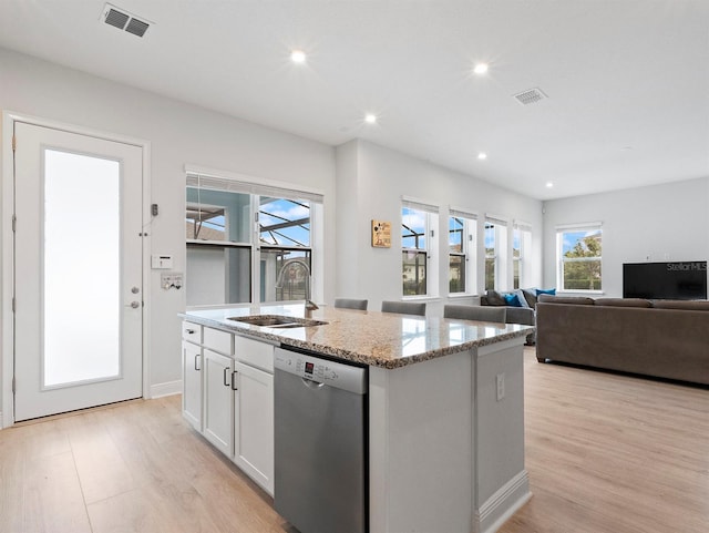 6875 Bridgman St, Orlando, FL 32827 - kitchen with dishwasher, a sink, an island with sink, light wood-style floors, and light stone counters