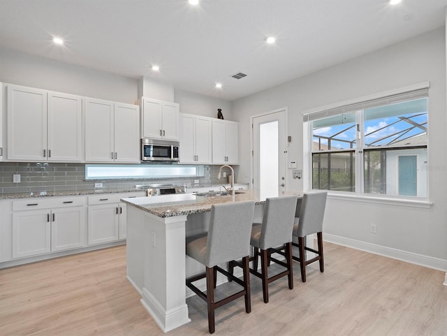 6875 Bridgman St, Orlando, FL 32827 - kitchen featuring appliances with stainless steel finishes, a sink, decorative backsplash, light wood-style floors, and recessed lighting