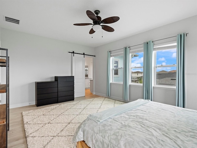 6875 Bridgman St, Orlando, FL 32827 - bedroom featuring a barn door, baseboards, light wood-style floors, and ceiling fan