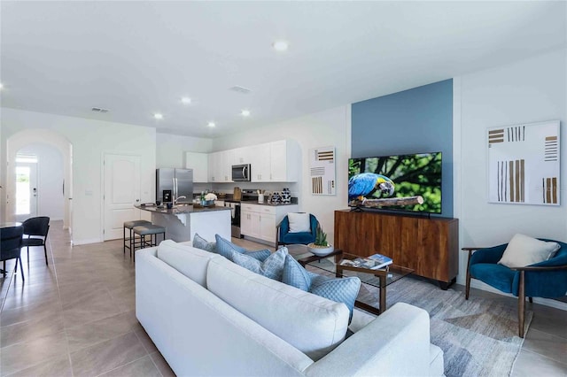 1302 Isleta Loop, Kissimmee, FL 34741 - living area featuring arched walkways, recessed lighting, light tile patterned floors, and baseboards