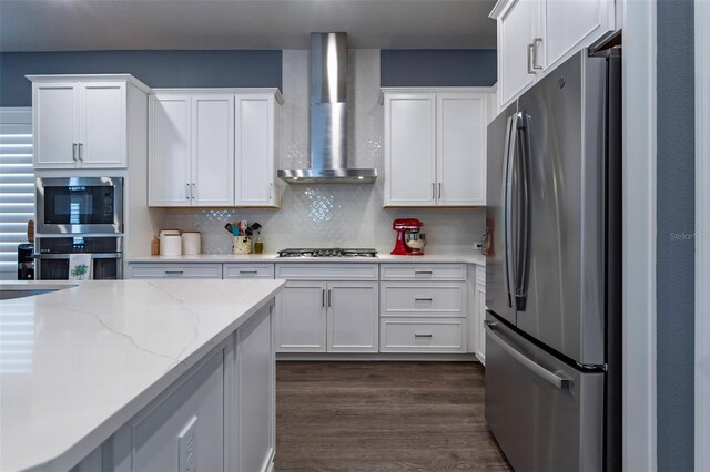 1212 Civitas Way, Winter Garden, FL 34787 - kitchen featuring appliances with stainless steel finishes, wall chimney range hood, white cabinets, dark wood-style flooring, and decorative backsplash