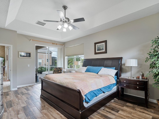 3840 Caledonia Ave, Apopka, FL 32712 - bedroom with access to outside, wood finished floors, baseboards, and a tray ceiling